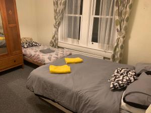 1 dormitorio con 2 camas y toallas amarillas. en O'Reilly's Holiday House, en Bath