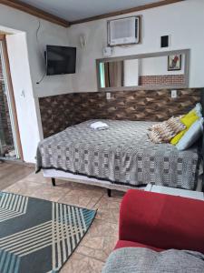 a bedroom with two beds and a tv on the wall at Pousada Marambaia Café - Praiana, econômica, Com café da manhã, piscina e hidromassagem ao ar livre - Frente para o mar in Barra de Guaratiba