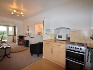 a kitchen with a stove and a living room at 1 Bed in Tavistock OTWIN in Lamerton