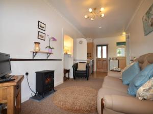 a living room with a couch and a fireplace at 1 Bed in Tavistock OTWIN in Lamerton