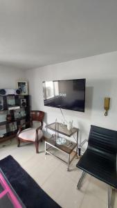 uma sala de estar com uma televisão de ecrã plano na parede em APARTAMENTO CHAPINERO CENTRAL em Bogotá