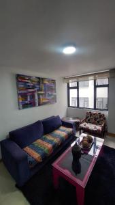 uma sala de estar com um sofá azul e uma mesa em APARTAMENTO CHAPINERO CENTRAL em Bogotá