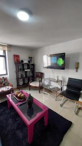 sala de estar con mesa y TV en APARTAMENTO CHAPINERO CENTRAL, en Bogotá