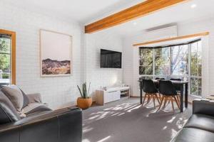 a living room with a couch and a table and chairs at Cosy renovated 2 bed villa in superb location in Hobart