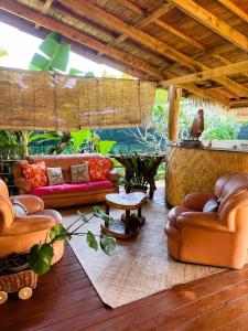 a living room with leather couches and a table at Villa Ruma Maria in Uturoa