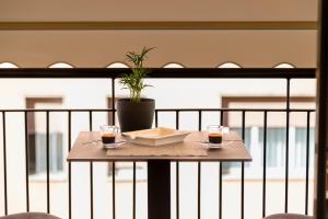 una mesa con dos vasos y una planta en el balcón en Guest House Al Viale, en Caltagirone