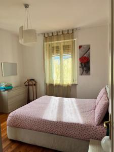 - une chambre avec un lit rose et une fenêtre dans l'établissement Al borgo di Sant'Orso - CIR 0342, à Aoste