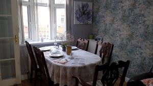 a dining room table with a white table cloth on it at Iris House in Belfast