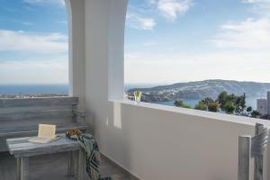 a white balcony with a table and a window at Aspronisi Luxury Villa with Caldera View in Megalokhori