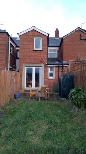 a yard with two chairs and a table in front of a house at Iris House in Belfast