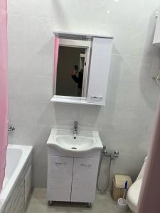 una persona que toma una foto de un baño con lavabo en ЖК Махаббат, en Aktau