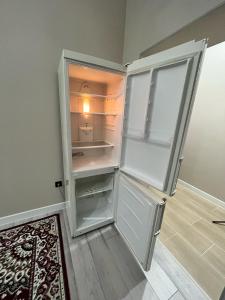 an empty refrigerator with its door open in a room at ЖК Махаббат in Aktau