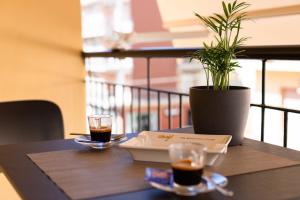 una mesa con dos vasos de café y una maceta en Guest House Al Viale, en Caltagirone