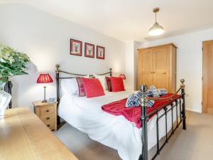 a bedroom with a large bed with red pillows at 2 Bed in York 64455 in Sheriff Hutton