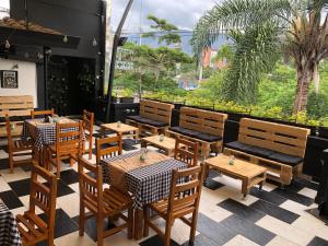 un restaurante con mesas y sillas de madera y una gran ventana en Aqua Lux, en Medellín