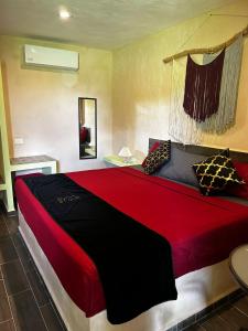 a bedroom with a large bed with red sheets and pillows at Casa Fausto’s in Azcorra