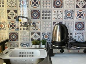 - une cuisine avec un évier et une cuisinière avec du carrelage dans l'établissement Ras el hanut appartamento a guéliz, à Marrakech
