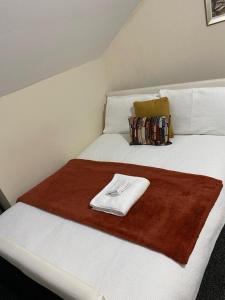 a white bed with a towel on top of it at Comfortable 2beds house 4 contractors & staycation in Leeds