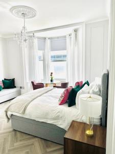 a bedroom with a large bed and a chandelier at Eden House & Aquila House - Beach Apartments & Suites in Saint Helier Jersey