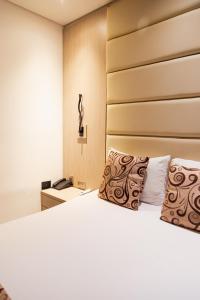 - une chambre avec un lit blanc et 2 oreillers dans l'établissement Hotel Laureles Loft, à Medellín