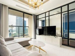 uma sala de estar com um sofá e uma televisão em The Rixx Downtown Apartment@D1/pool/gym/Operahouse em Ho Chi Minh