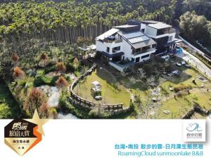 uma imagem de uma casa grande com um quintal em Roaming Cloud Sun Moon Lake B&B em Yuchi