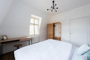 a bedroom with a bed and a desk and a window at Laland Apartment in Karlovy Vary