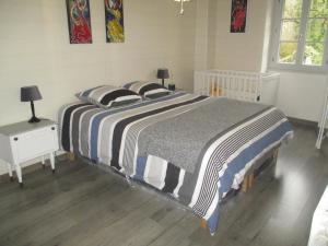 a bed with a striped blanket in a bedroom at Gite Le bout du monde in Baume-les-Messieurs