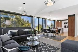 sala de estar con sofá y mesa en New Architect designed Coastal retreat-water views en Hobart
