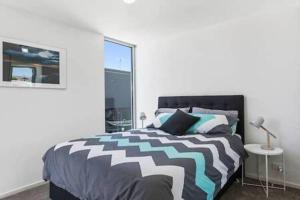 Un dormitorio con una cama en blanco y negro y una ventana en New Architect designed Coastal retreat-water views en Hobart