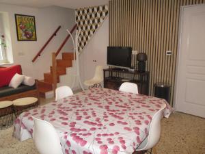 a living room with a table and chairs and a staircase at Gite Le bout du monde in Baume-les-Messieurs