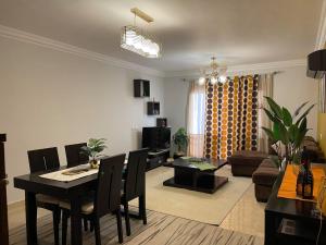 ein Wohnzimmer mit einem Tisch und einem Esszimmer in der Unterkunft Quiet and distinctive apartment with a wonderful v in Madinaty