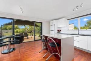 a kitchen with a table and chairs in a house at The Baker's Cottage in the Heart of Richmond Sleeps 6 in Hobart