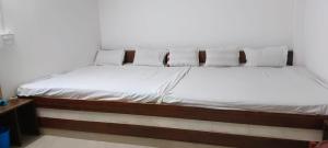 a bed with white sheets and pillows in a room at Ocean front beach resort in Tajpur