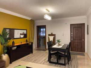 a living room with a table and a yellow wall at Quiet and distinctive apartment with a wonderful v in Madinaty