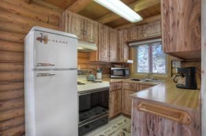 a white refrigerator in a kitchen with wooden cabinets at Turtle House in South Fork, CO in South Fork