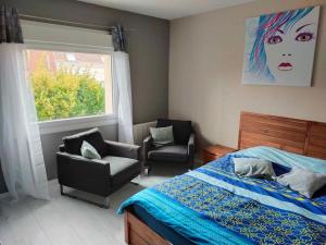 ein Schlafzimmer mit einem Bett, einem Stuhl und einem Fenster in der Unterkunft La maison aux escargots *Jacuzzi* in Hénin-Beaumont