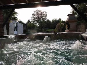 a body of water with rapids in a yard at La maison aux escargots *Jacuzzi* in Hénin-Beaumont