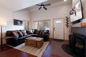 salon z czarną skórzaną kanapą i kominkiem w obiekcie Pine Acres - Unit 123 w mieście Durango