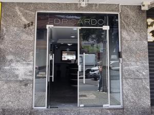 uma porta de vidro de um edifício com um sinal em Belvedere em Curitiba