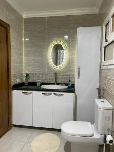 a bathroom with a white toilet and a sink at Quiet and distinctive apartment with a wonderful v in Madinaty