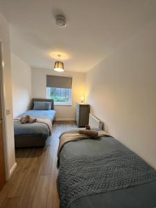 een slaapkamer met 2 bedden en een raam bij Inchmurrin Townhouse, Loch Lomond in Bonhill