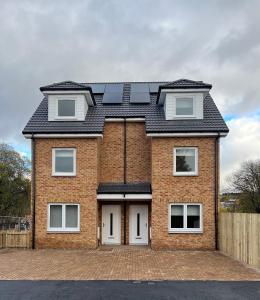 a brick house with solar panels on the roof at Inchmurrin Townhouse, Loch Lomond in Bonhill