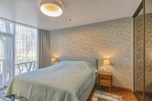 sypialnia z łóżkiem i dużym oknem w obiekcie SOLEMI w Druskienikach