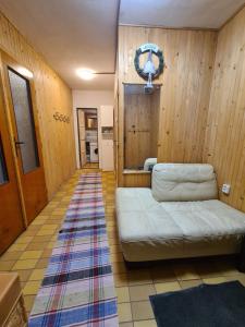 ein Wohnzimmer mit einem Sofa in einem Zimmer mit Holzwänden in der Unterkunft Chata pri Veľkej Rači in Oščadnica