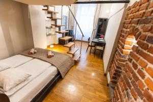 1 dormitorio con cama y pared de ladrillo en VINTAGE SENACKA APARTMENTS, en Cracovia