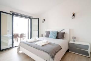 - une chambre blanche avec un lit et une grande fenêtre dans l'établissement Casa Azinheira 1ºa- Albufeira, à Albufeira