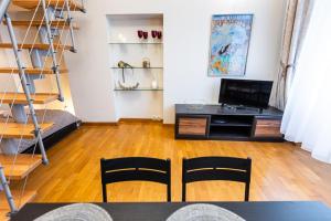 a living room with a tv and a table and chairs at VINTAGE SENACKA APARTMENTS in Krakow