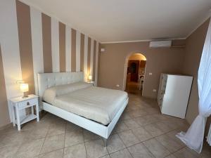 a bedroom with a bed and two tables and a refrigerator at Terrazza su Tocco in Tocco da Casauria