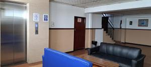una sala de espera con un sofá azul y un ascensor en HOTEL OCCIDENTAL David Chiriqui, en David
